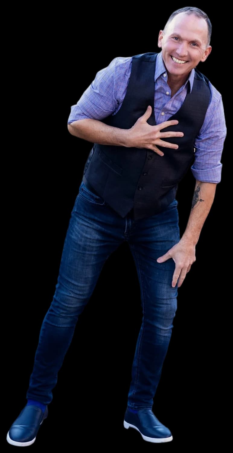 Dr. Kevin C. Snyder laughing, hand on his chest, in a vest and jeans