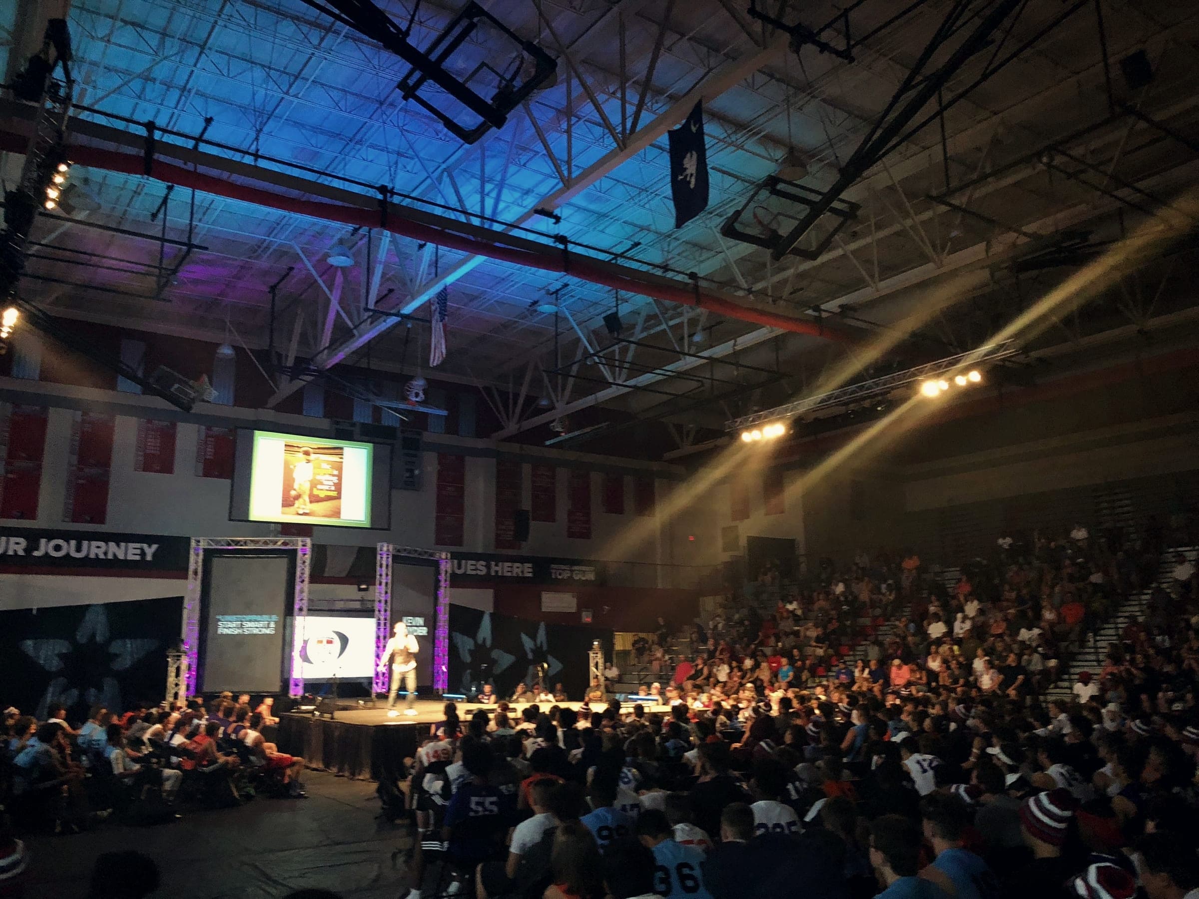 A packed arena of students facing a lit stage during one of Kevin’s keynotes
